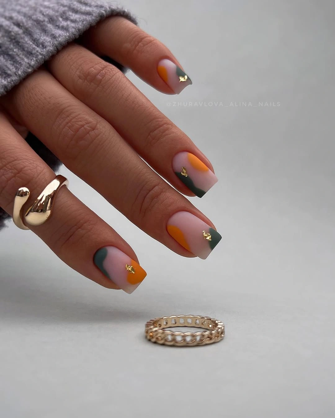 Medium almond pastel nails with coral green and metallic accents