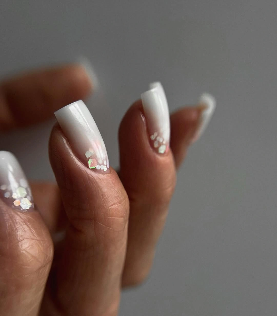 Long pale tapered nails with sparse floral sparkle details