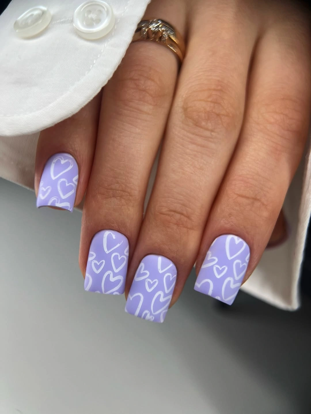 Short square lavender nails with white heart outlines