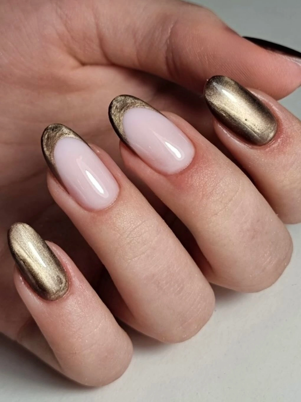 Soft nude oval nails with metallic bronze gold accents