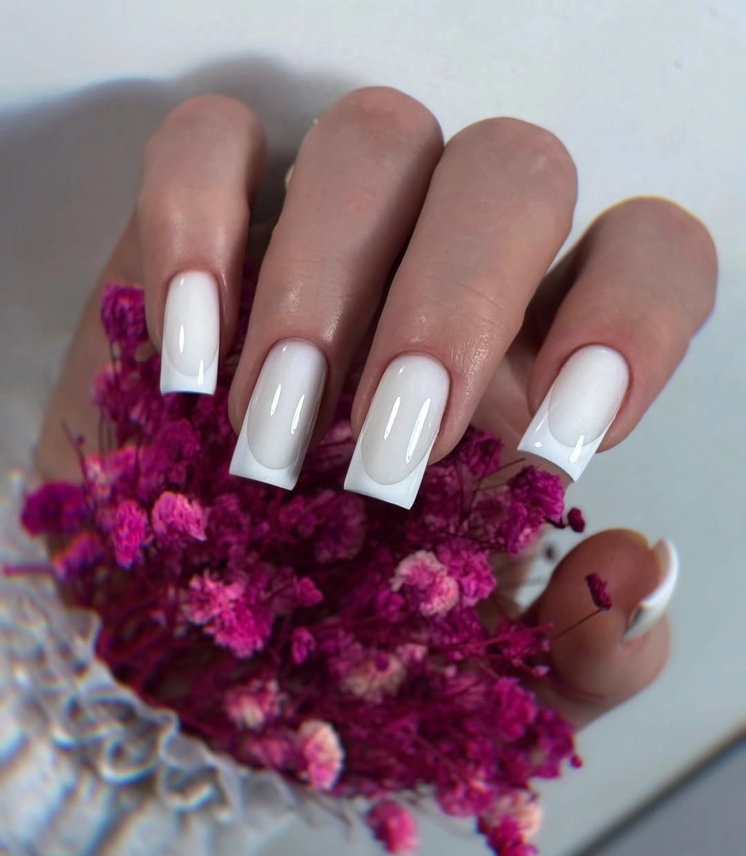 Long white square nails over a translucent pink base