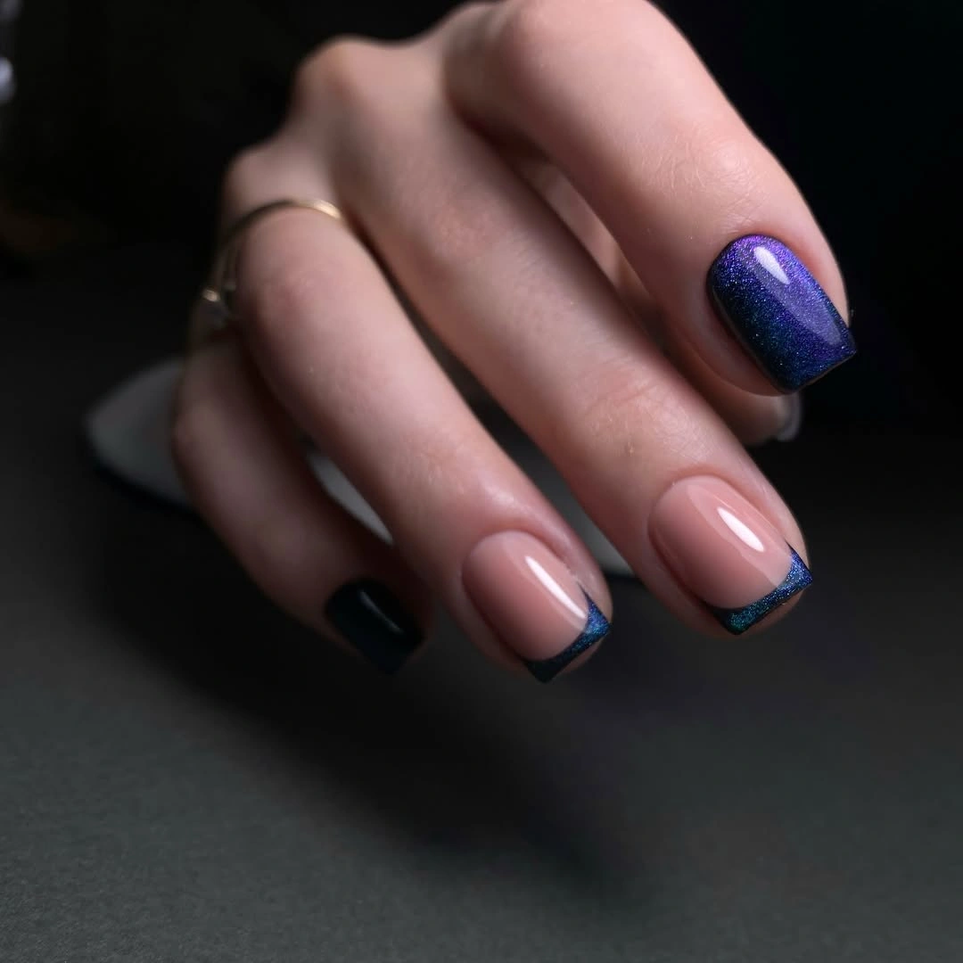 Nude almond nails with navy tips and a purple glitter accent