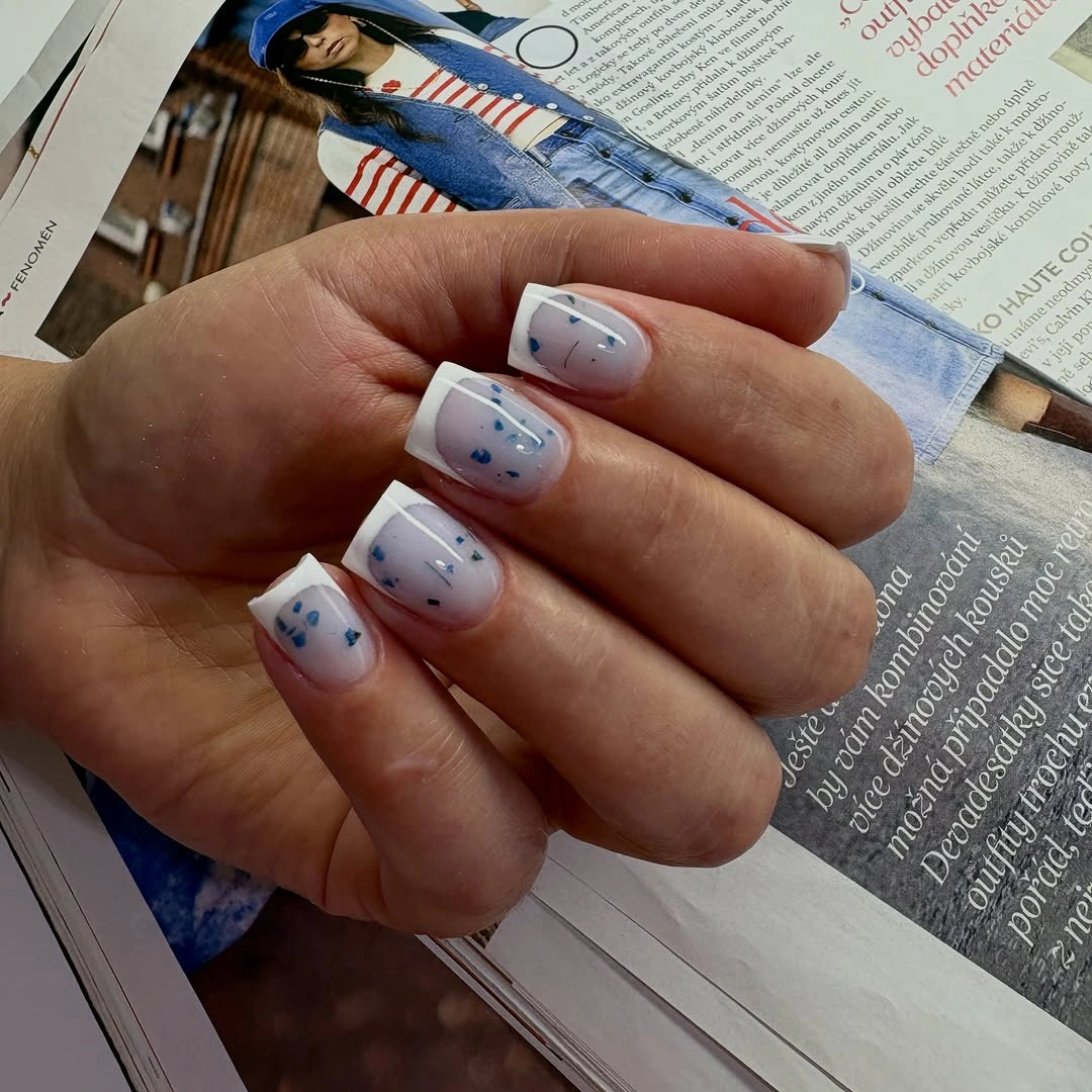 Short white square nails with tiny blue and orange line art