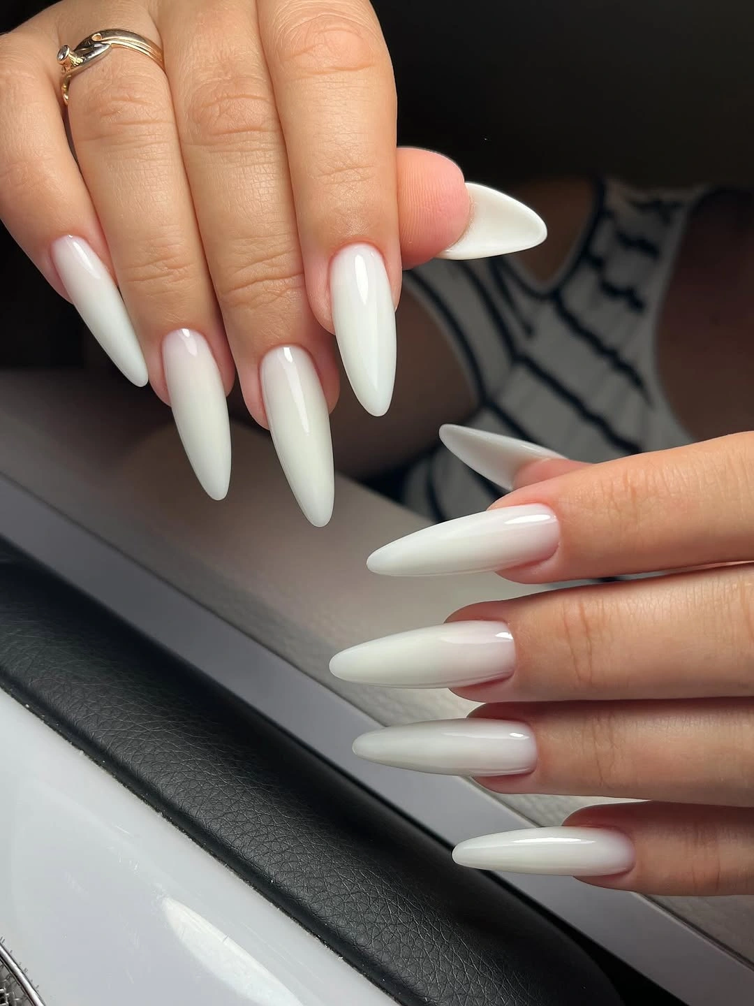 Long solid white almond nails against a dark background