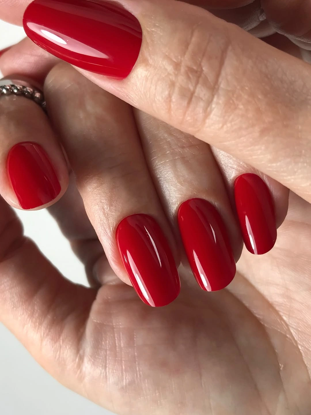 Medium glossy red rounded nails in a solid fall color