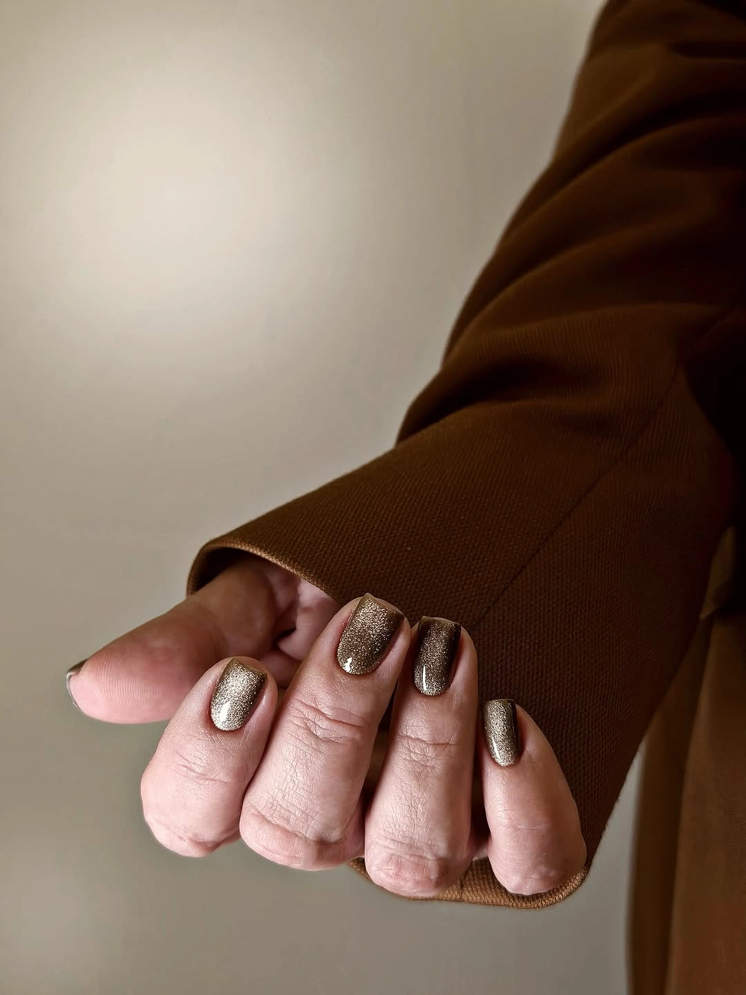 Short warm brown nails with subtle metallic shimmer