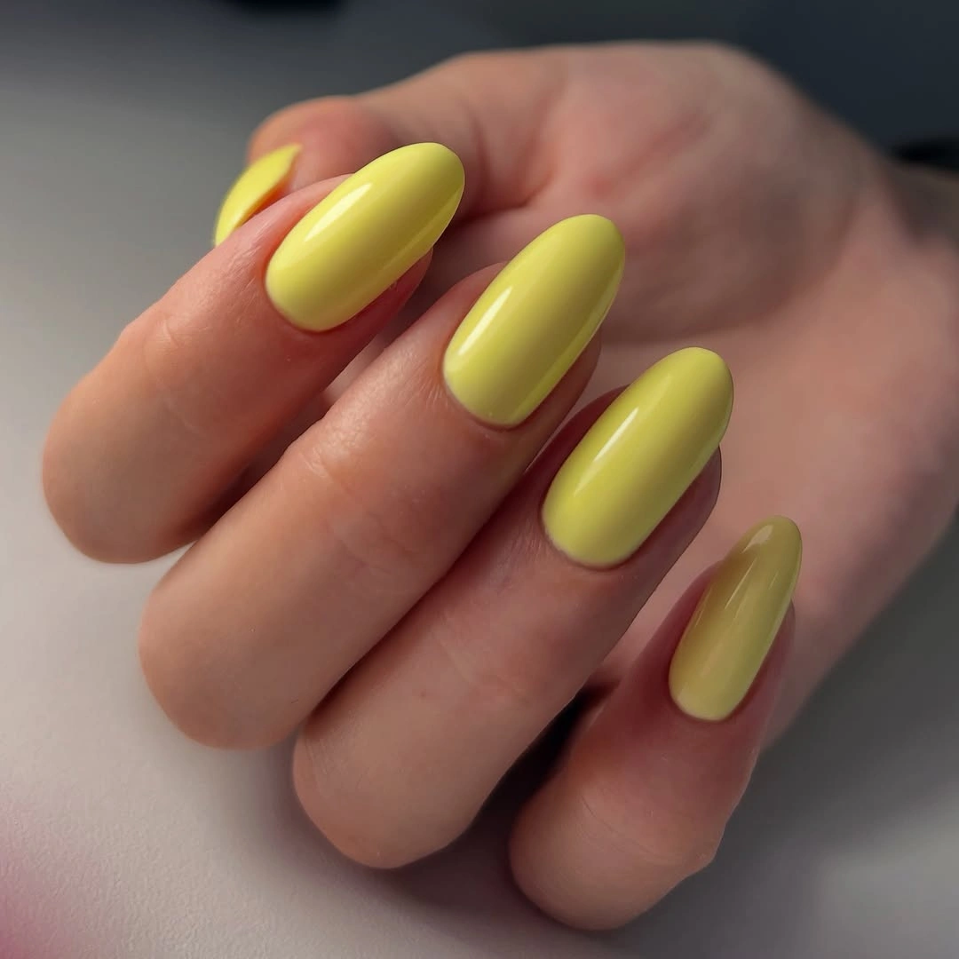 Medium-long glossy bright yellow almond nails