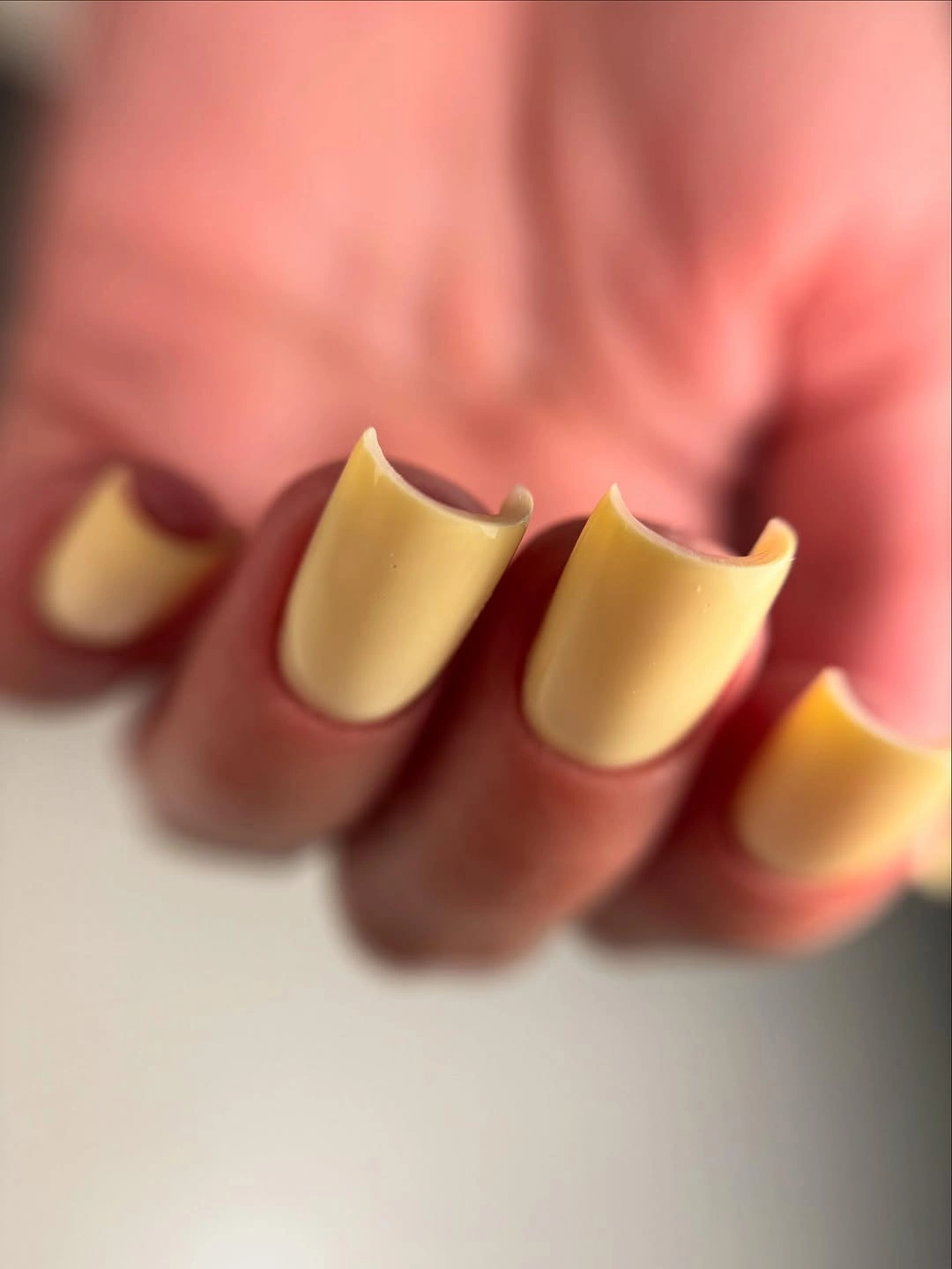 Short warm yellow nails with a soft matte-looking finish