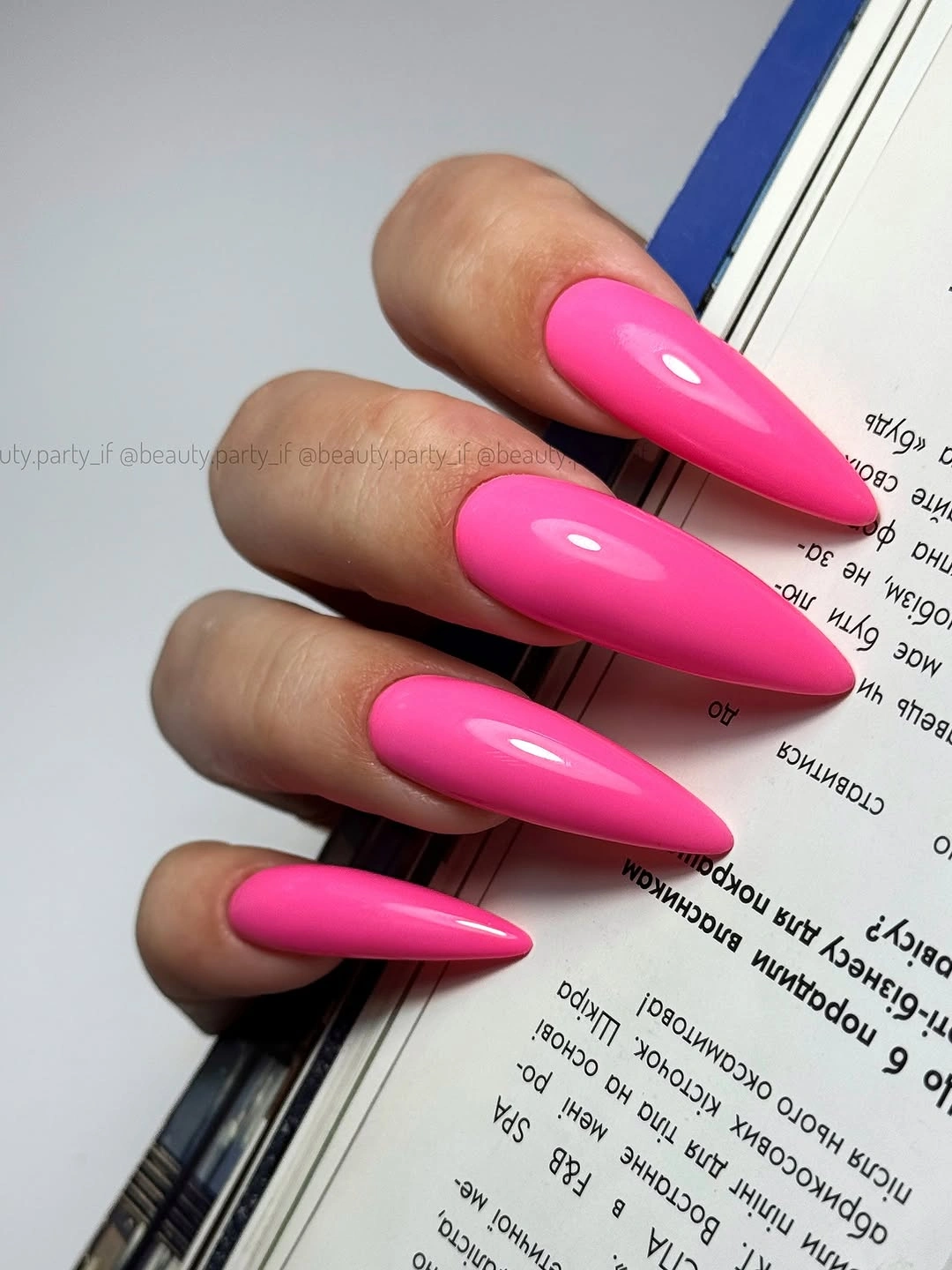 Long glossy vivid hot pink almond nails in a solid finish