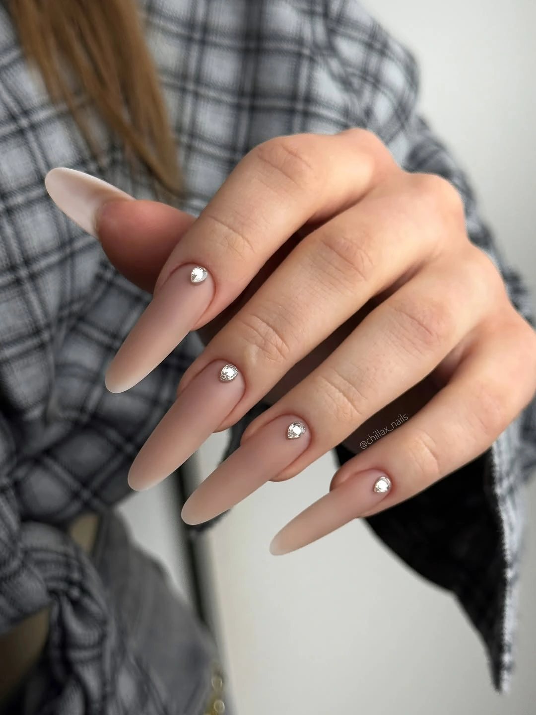 Long nude stiletto nails with sparse cuticle crystal accents