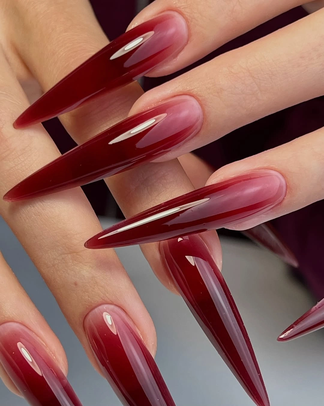 Long deep red stiletto nails with glossy layered color
