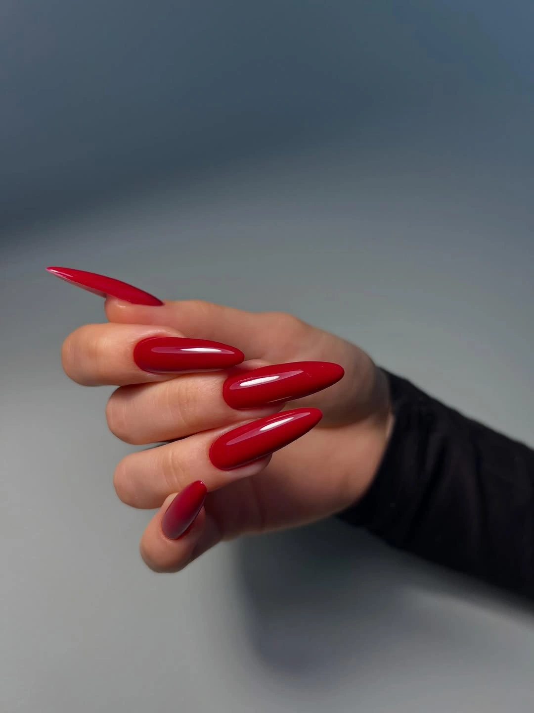 Long glossy cherry red stiletto nails in a solid finish