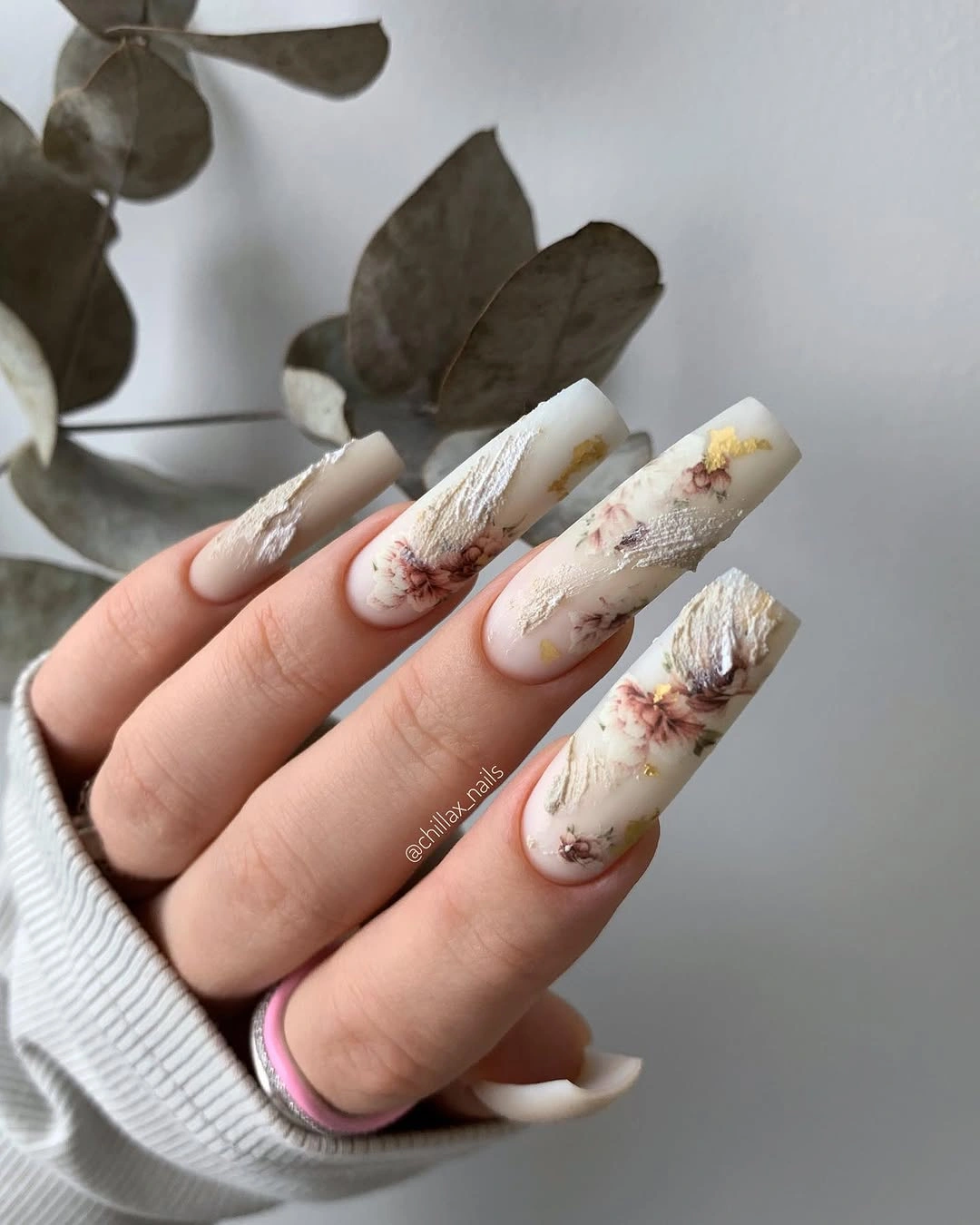 Long creamy coffin nails with brown marble strokes and floral accents