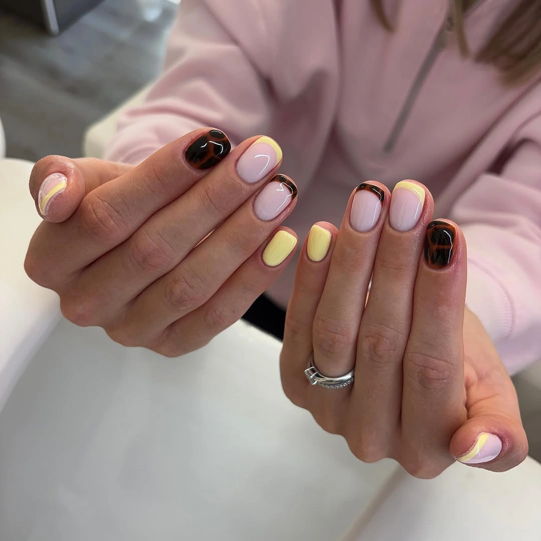 Short rounded pastel pink yellow black and purple accent nails