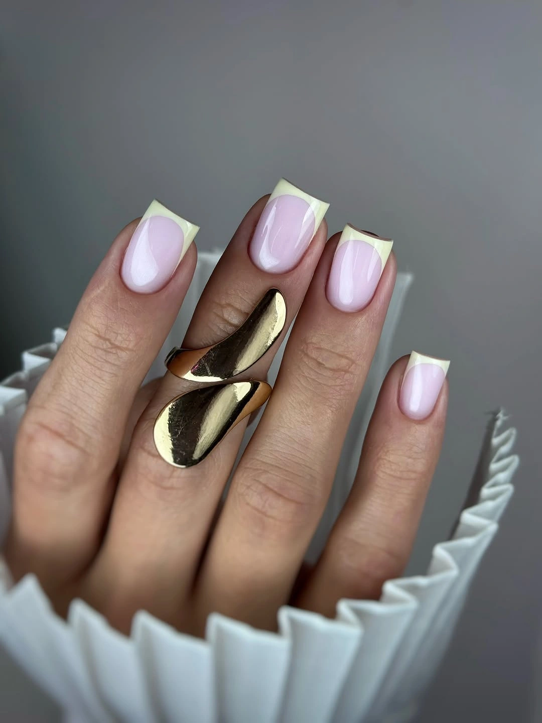 Medium almond pale pink nails with neon tips and gold accents