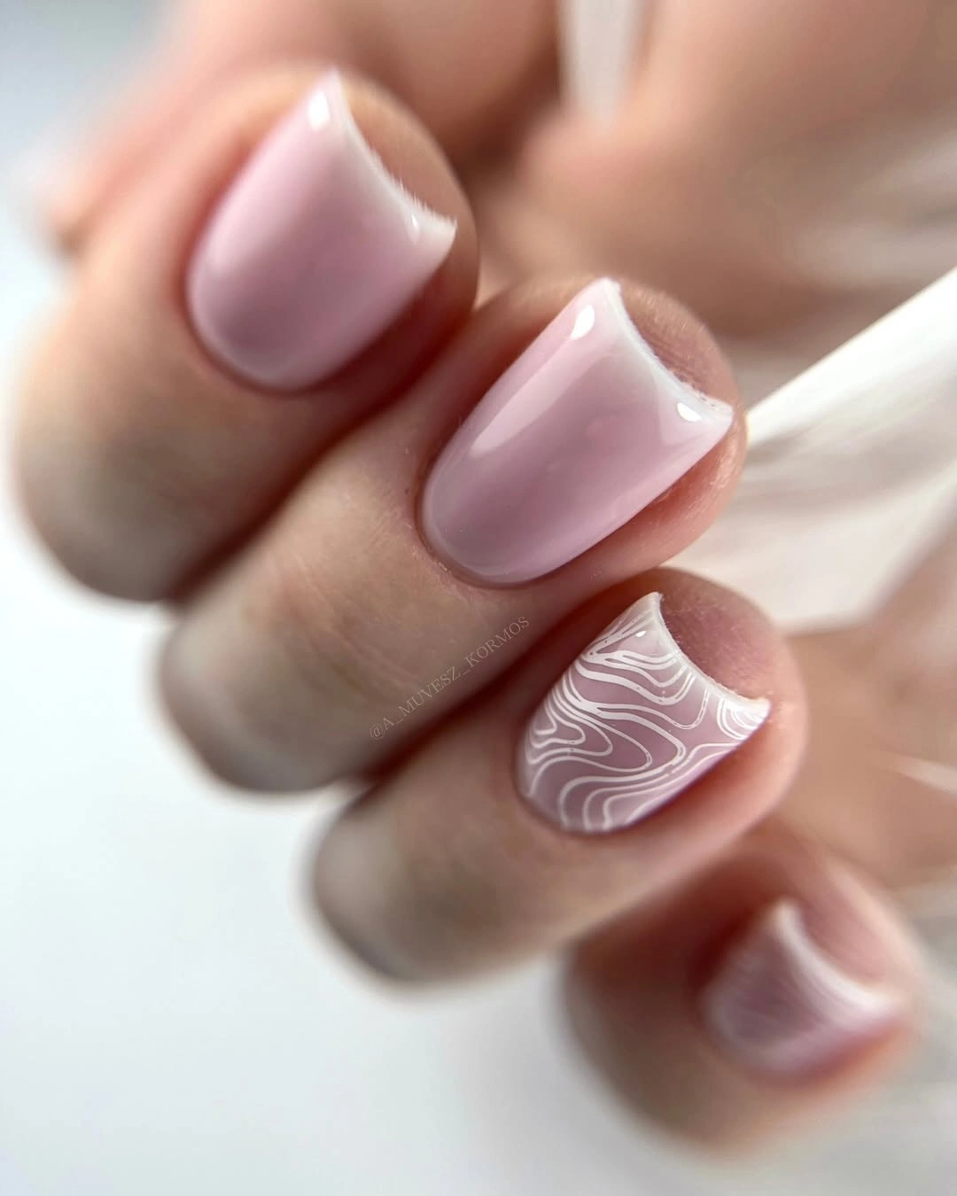 Short oval blush pink nails with white wavy accents