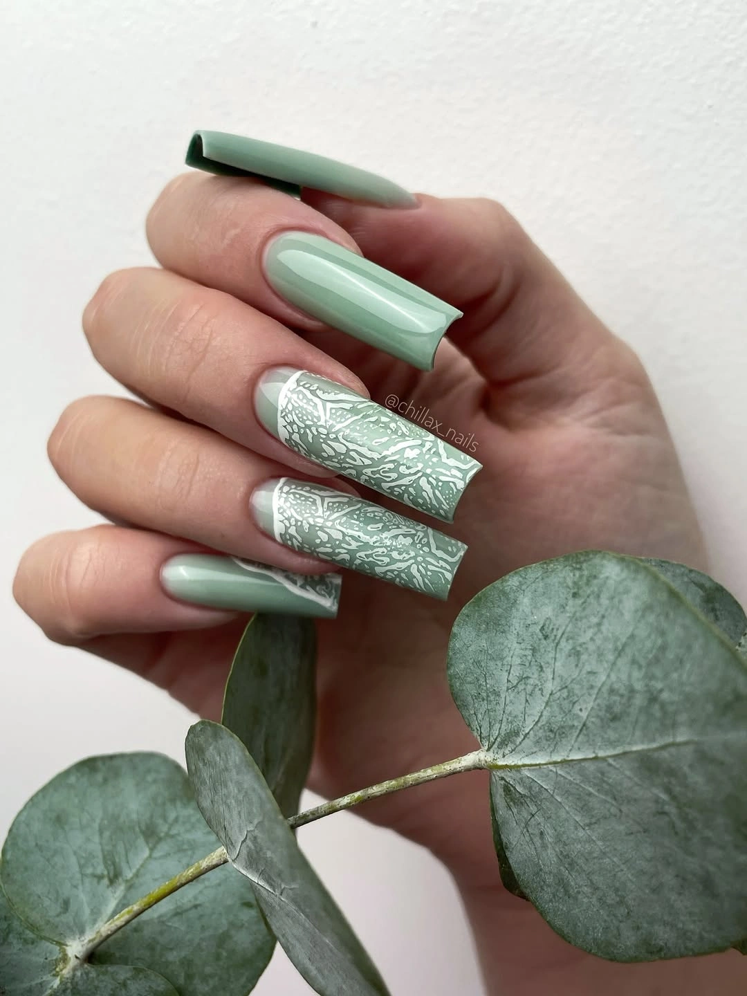 Long square sage green nails with white botanical accents