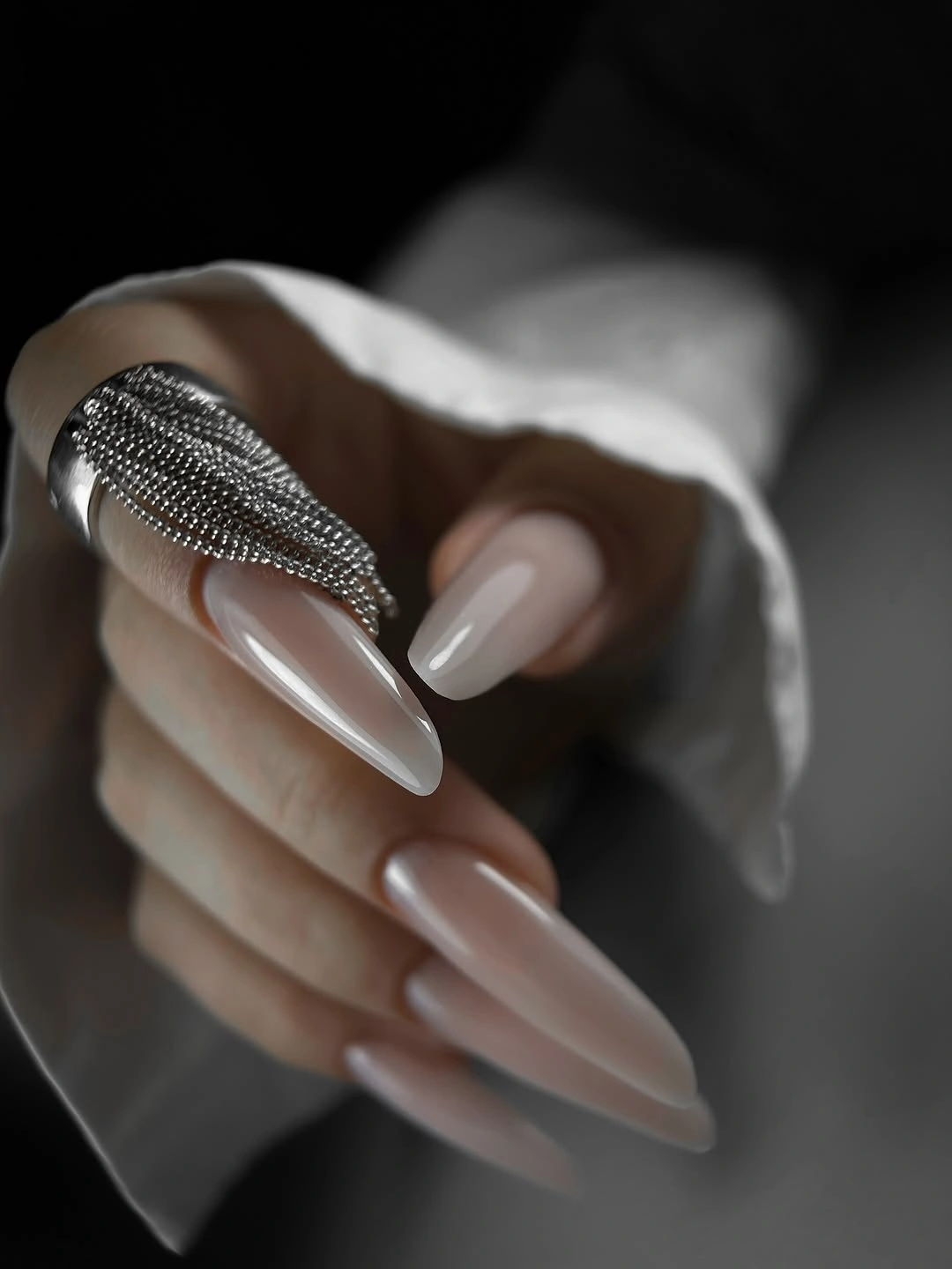 Long almond sheer nude nails with one silver textured accent