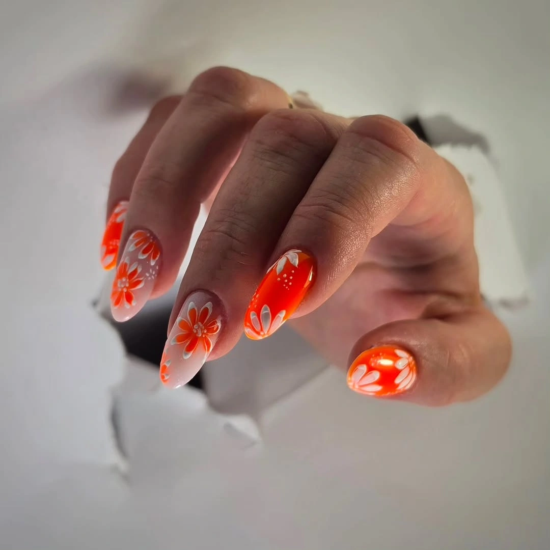 Vivid orange red almond nails with open white flowers