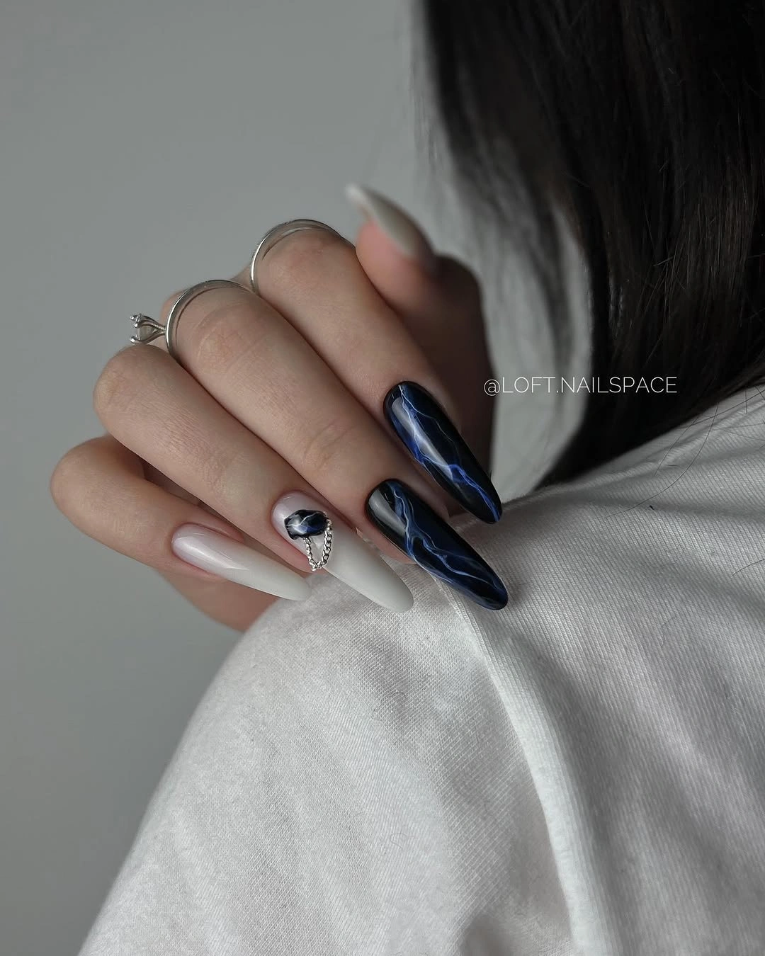 Long almond nails with reflective navy and pale accents