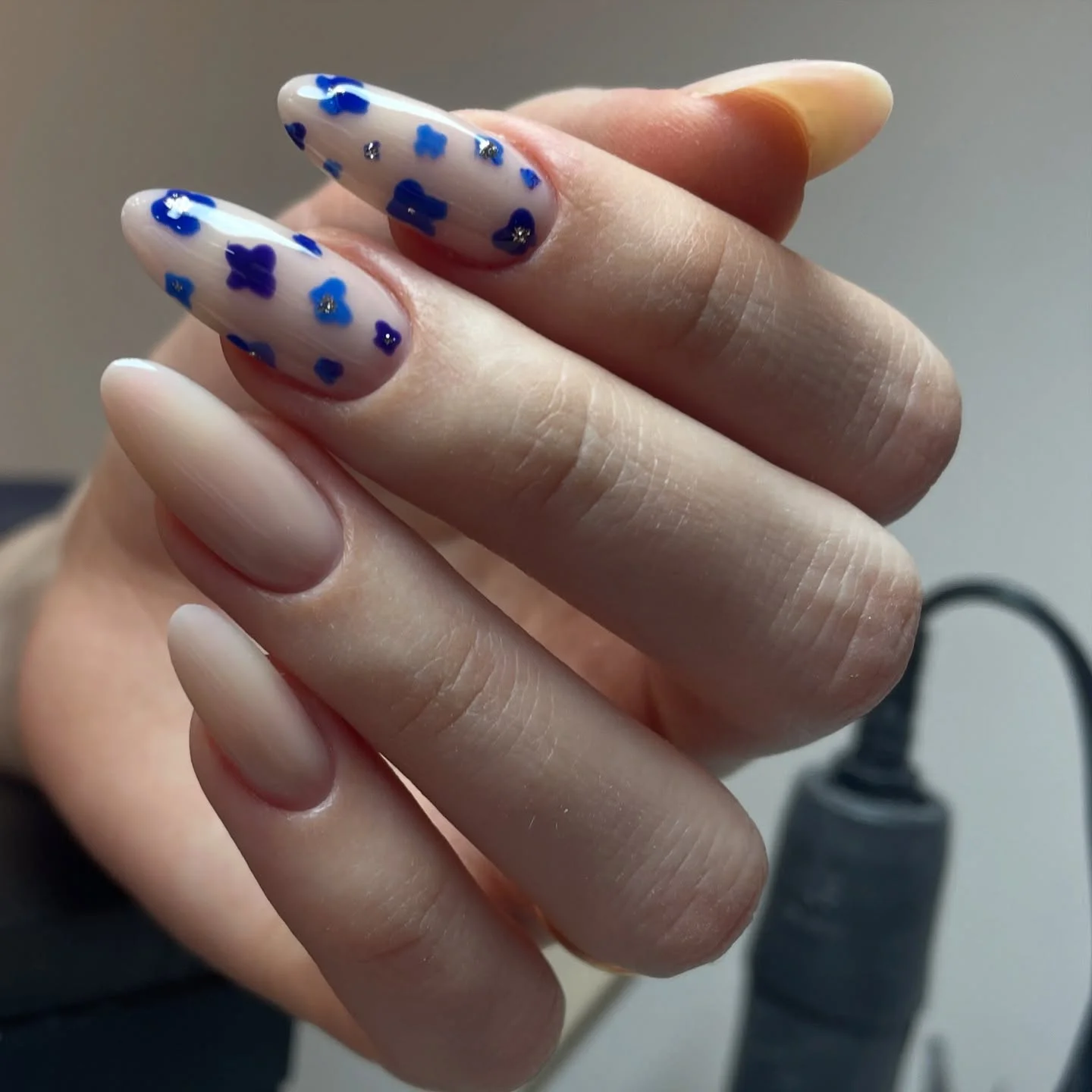 Short almond nails with tiny cobalt blue flowers on sheer pink