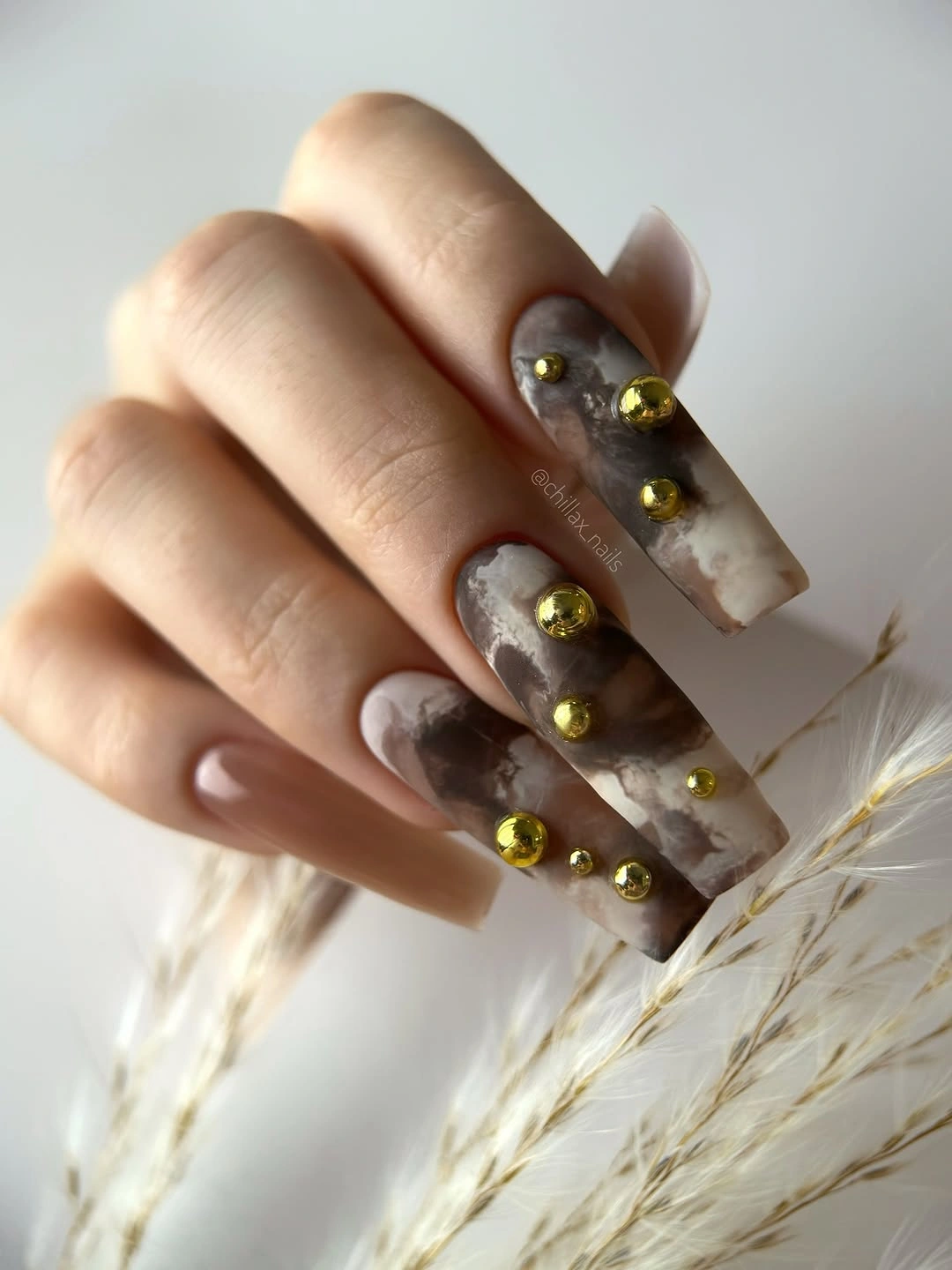 taupe matte nails with clustered amber and gold-looking accents