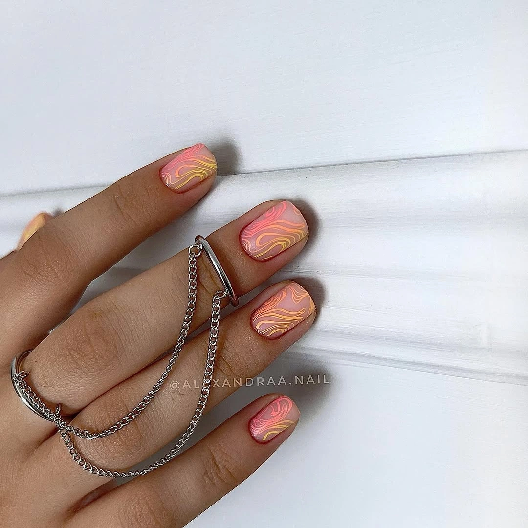 short peach pink nails with fine yellow coral and pink waves
