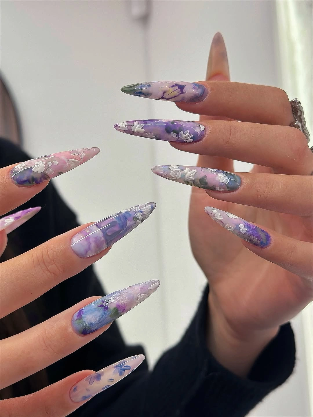long lavender almond nails with blue pink and lilac marble curves