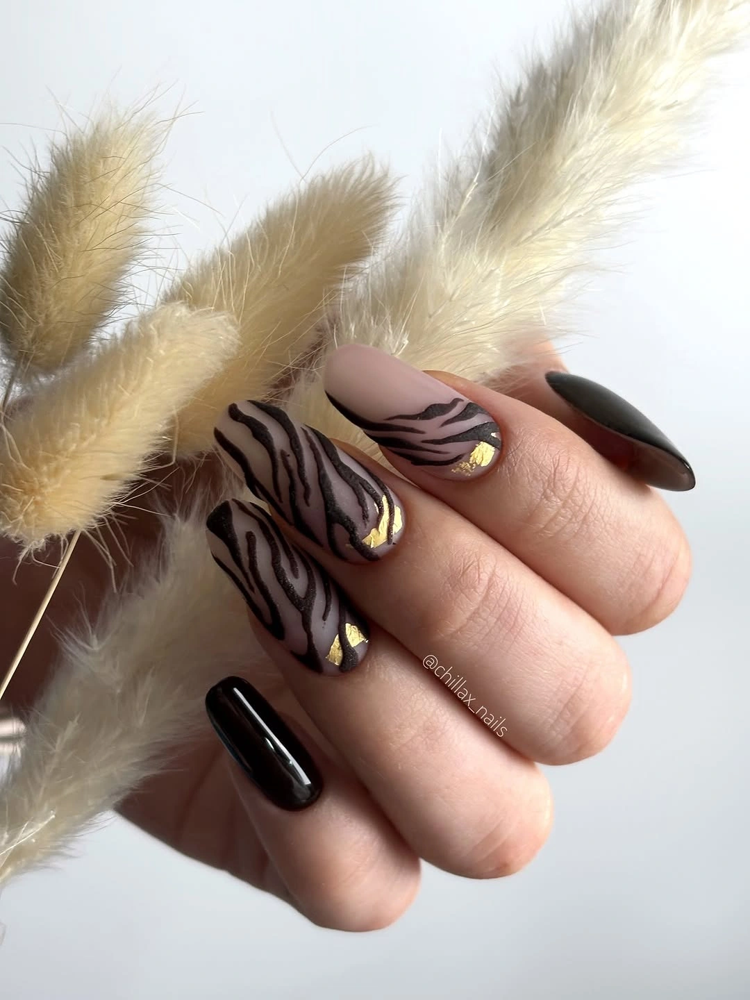 almond nails alternating glossy black and warm curved animal-like accents
