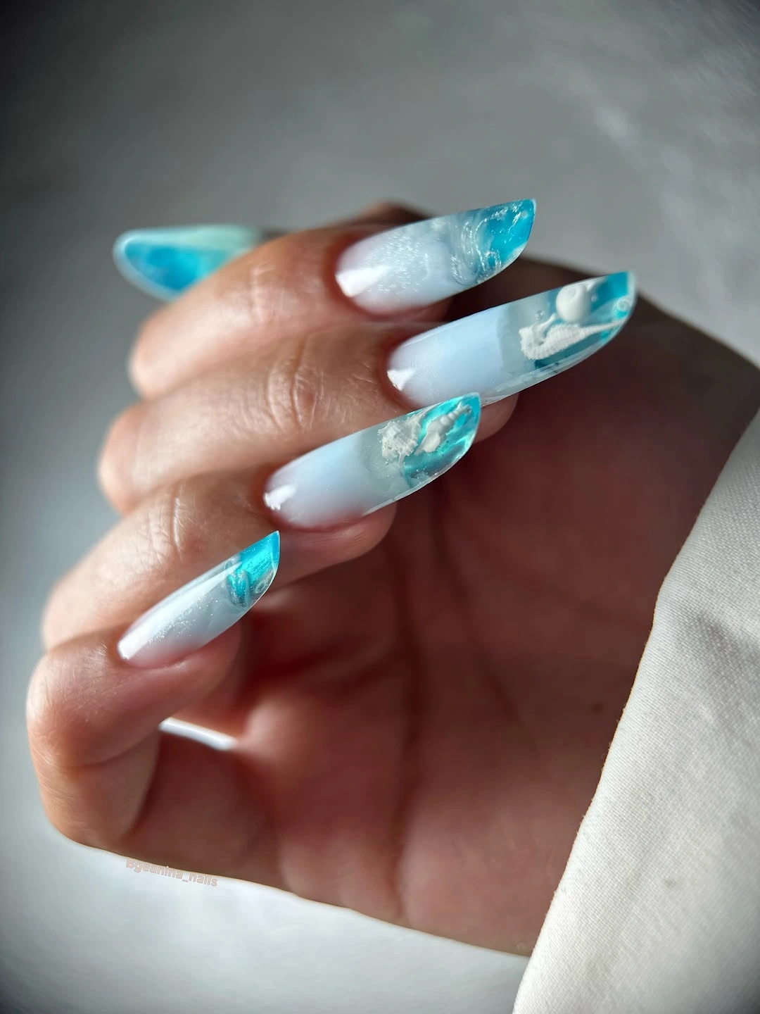 Long tapered white and turquoise marble nails with cloudy swirls