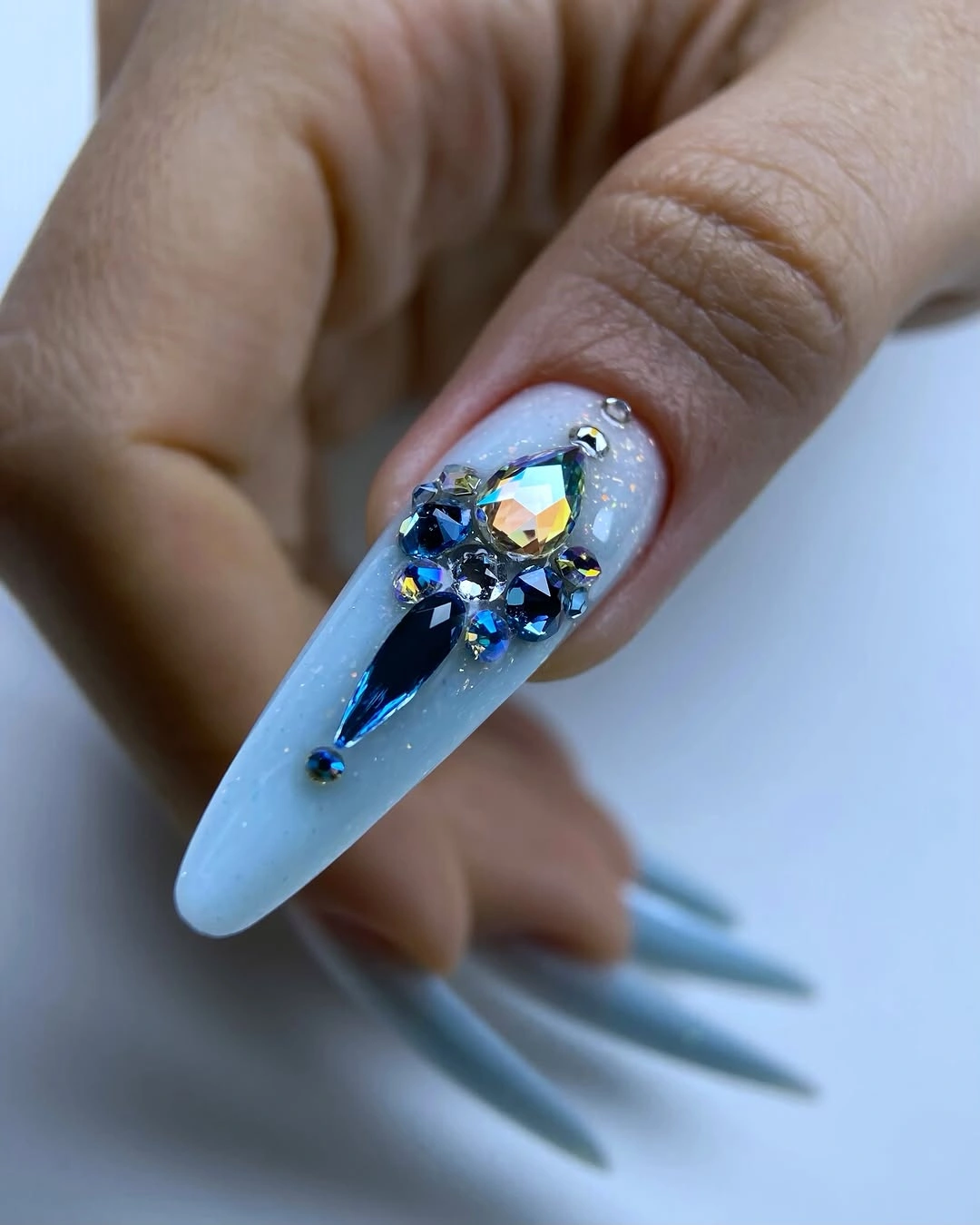 Long icy blue tapered nails with one iridescent jeweled accent