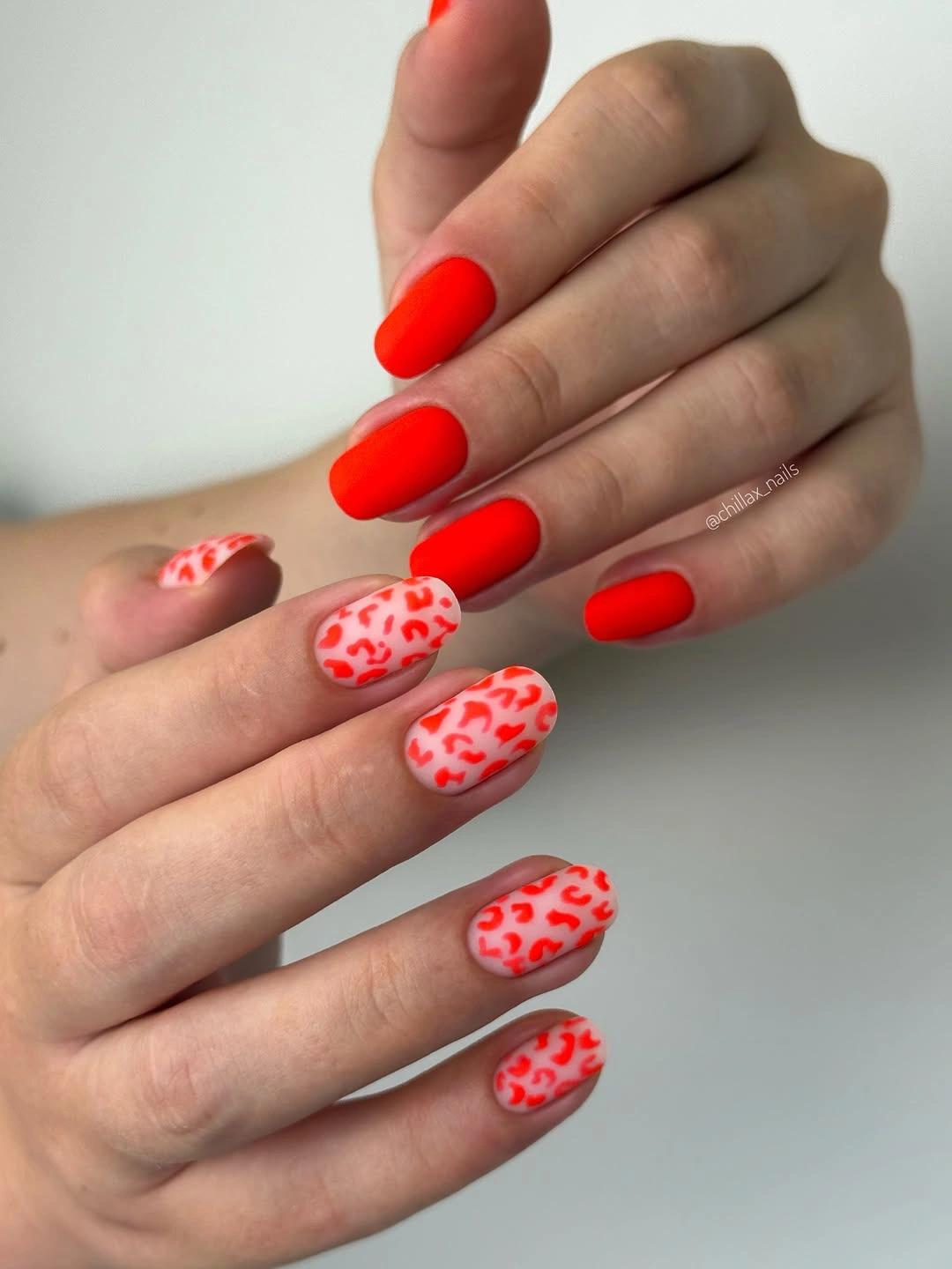 Medium almond red nails with white irregular spotted accents