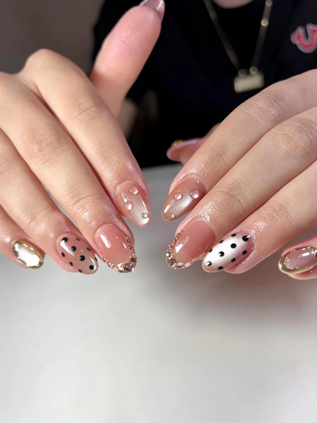 Medium almond nude nails with dots pearls and gold accents