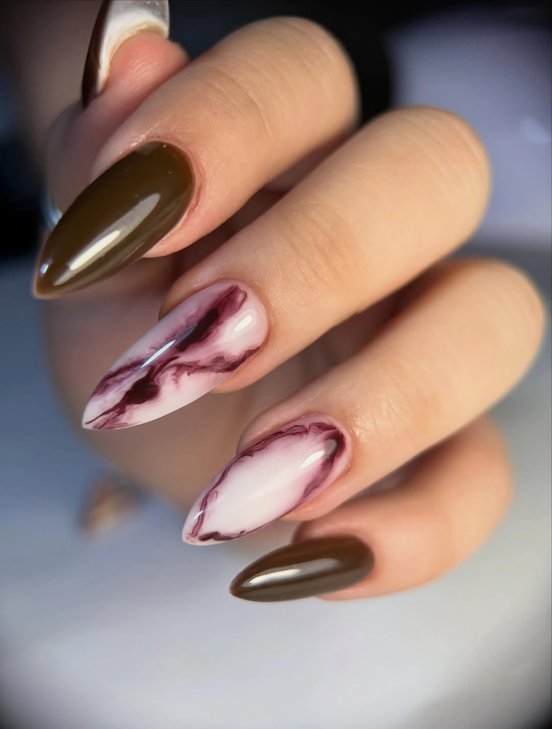 Long brown almond nails with creamy burgundy marbled accent