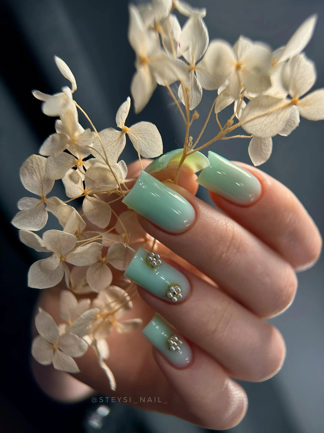 Medium aqua almond nails with a tiny floral pearl accent
