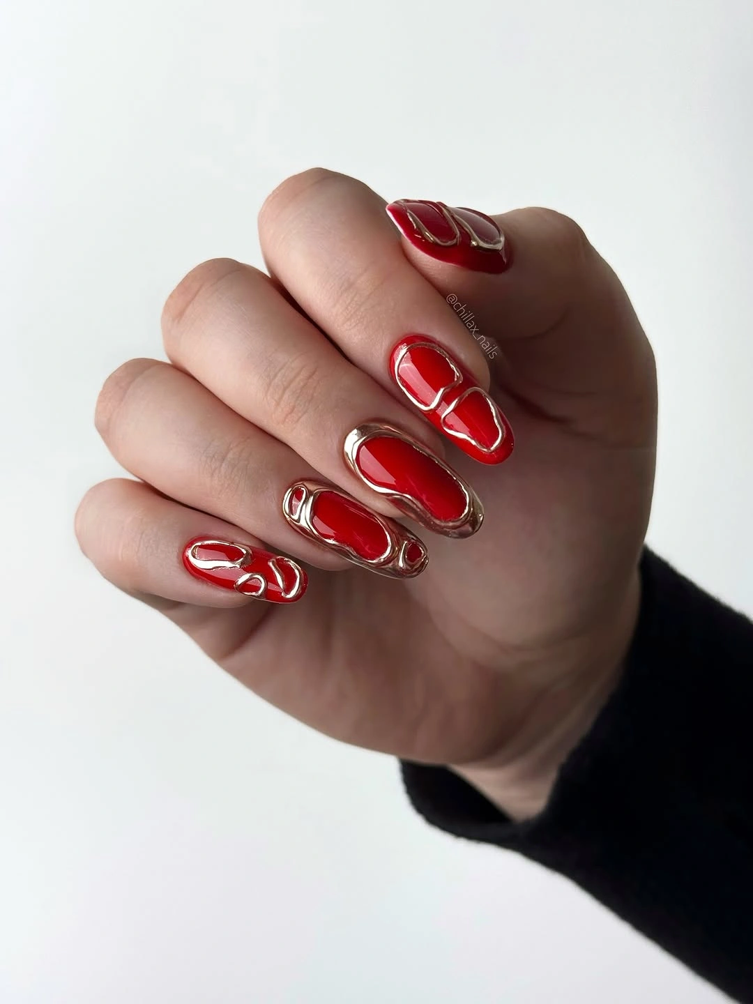 Long red almond nails with flowing silver line accents