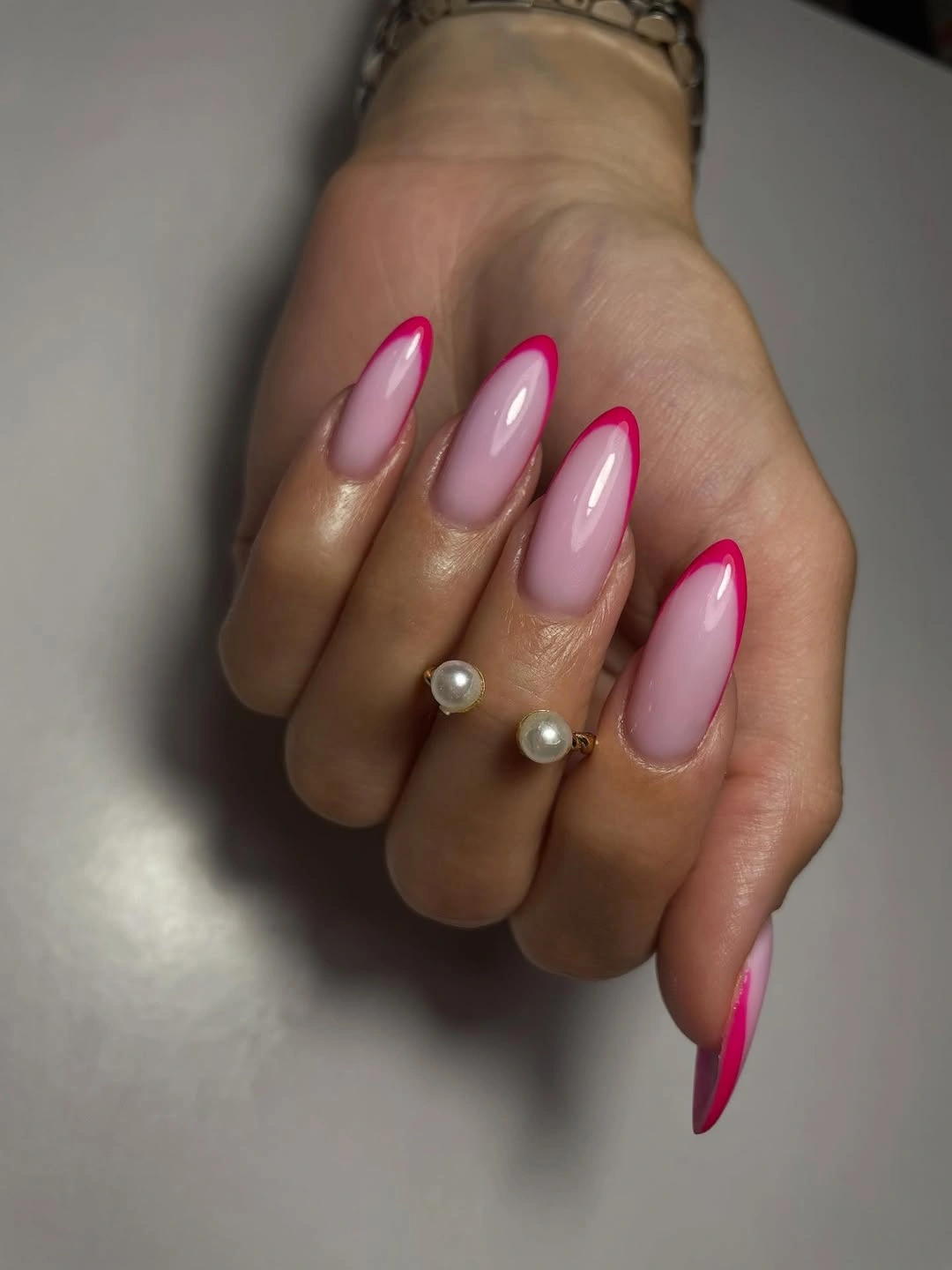 Long pink almond nails with hot pink tips and pearl accents
