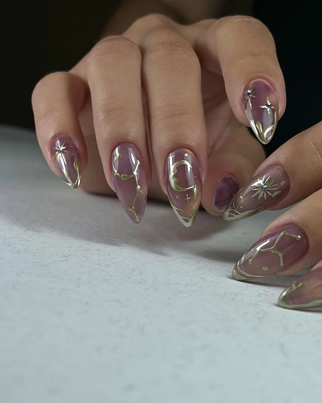 Smoky mauve almond nails with gold celestial art