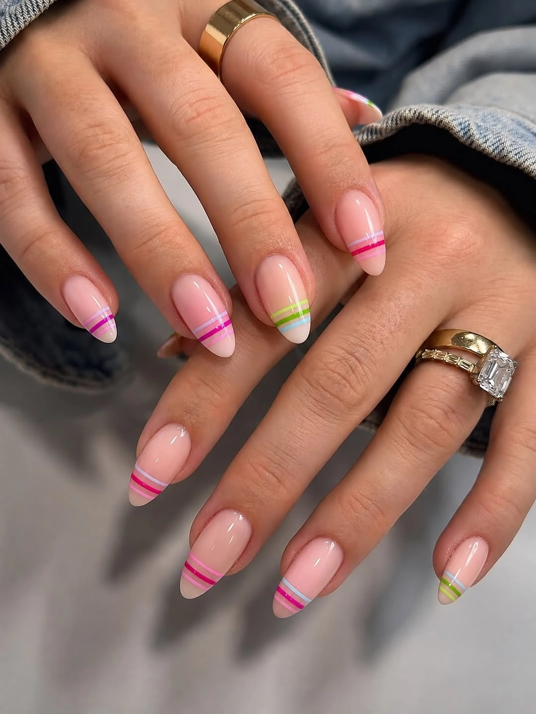 Glossy nude almond nails with thin neon bands