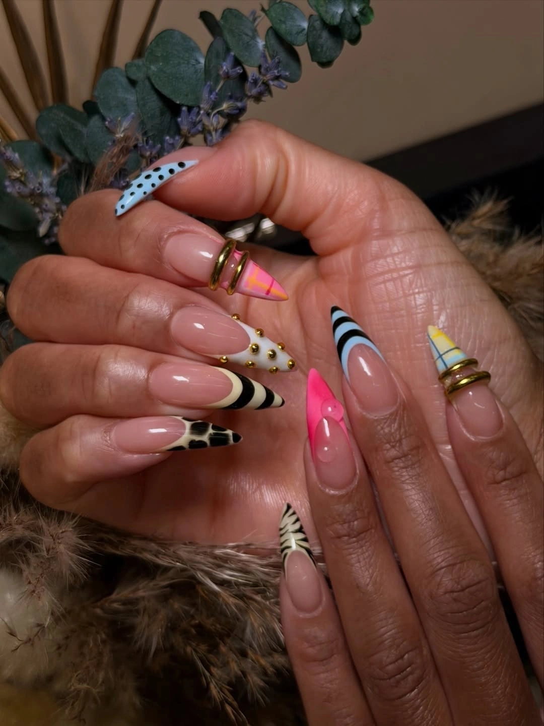 Mismatched stiletto tips with colorful patterns and rings