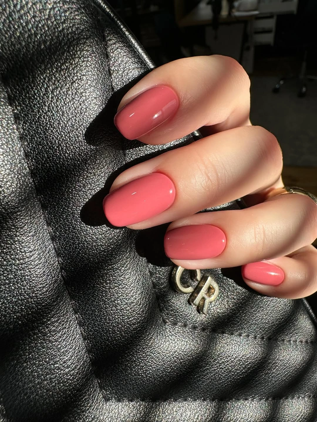 Glossy coral polish on short oval nails