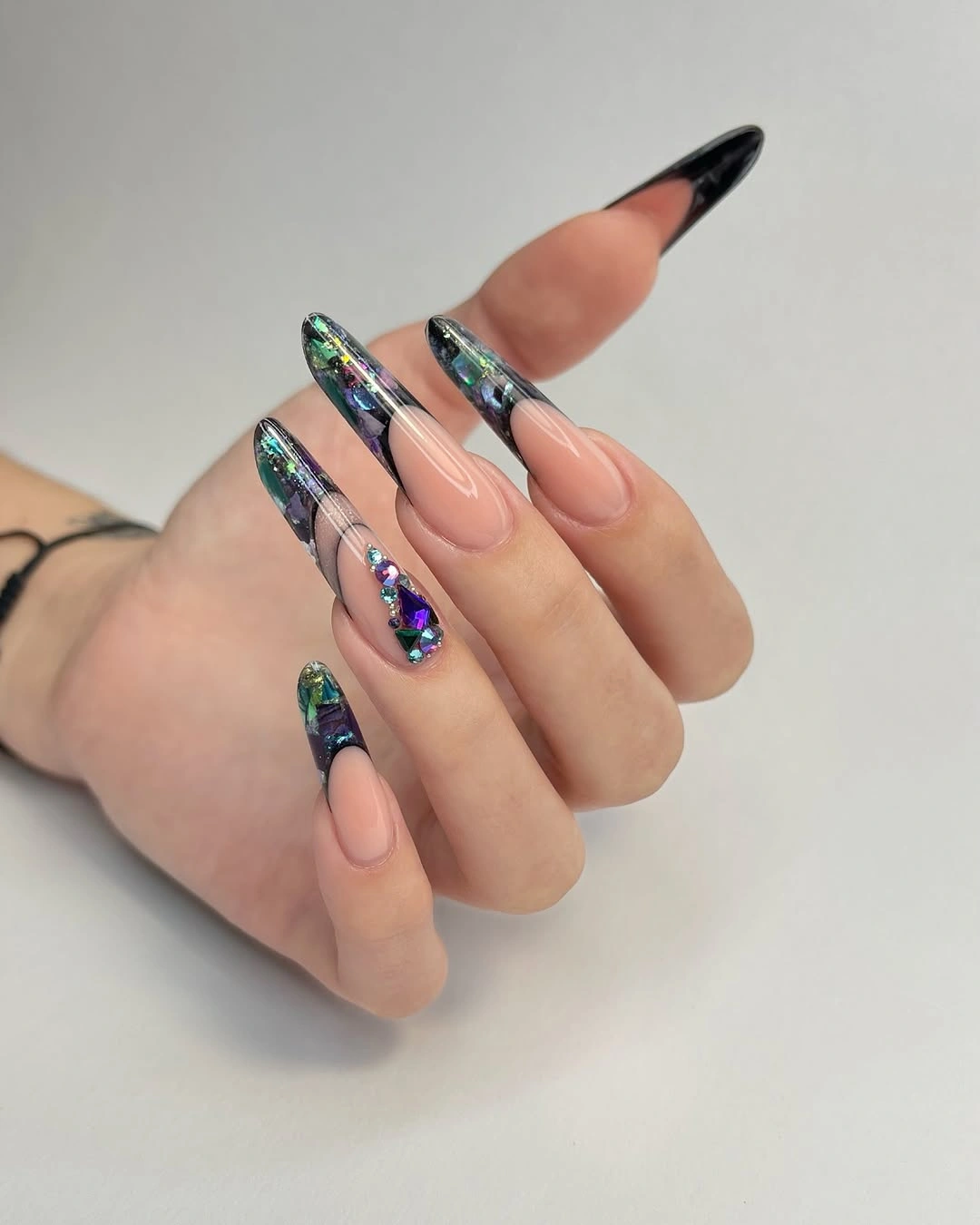 Black iridescent French tips on nude almond nails