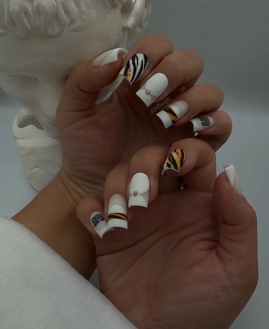 White square nails with amber tiger stripe accents