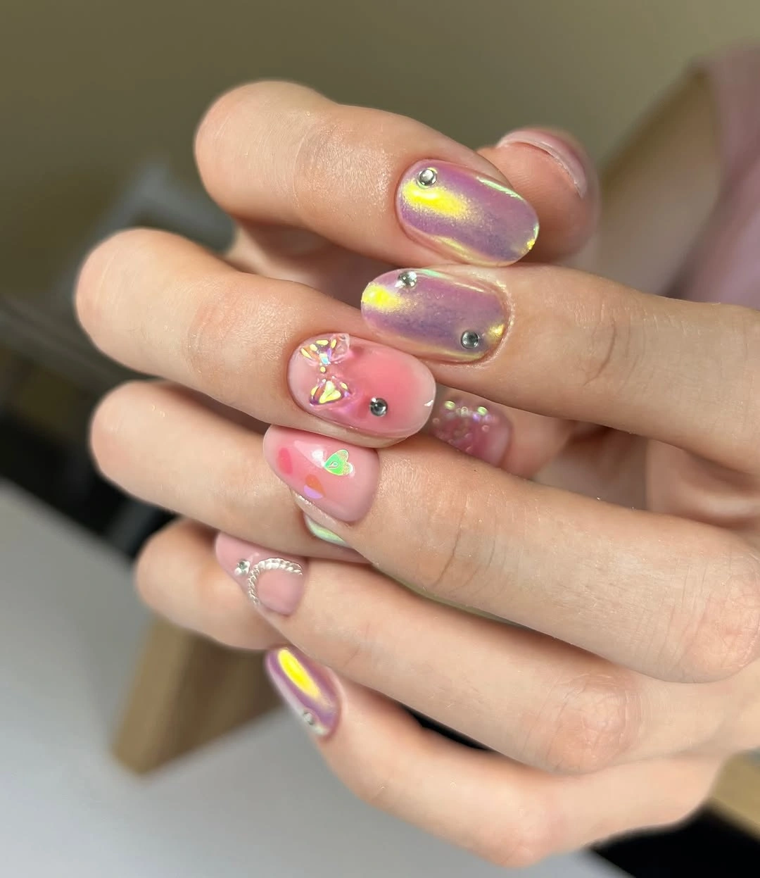 Short pearly pink nails with tiny charm accents