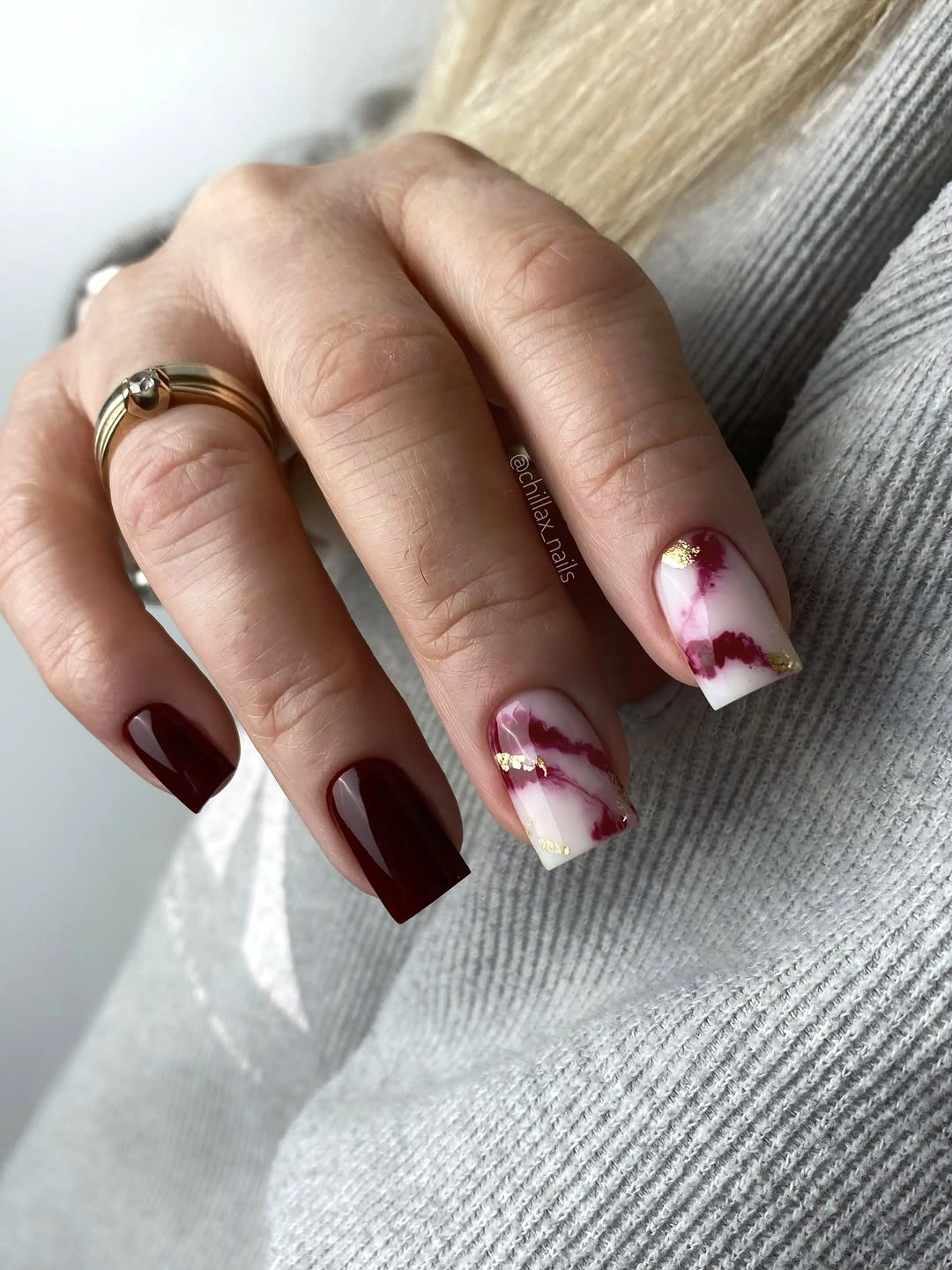 Long burgundy square nails with one pale marbled accent