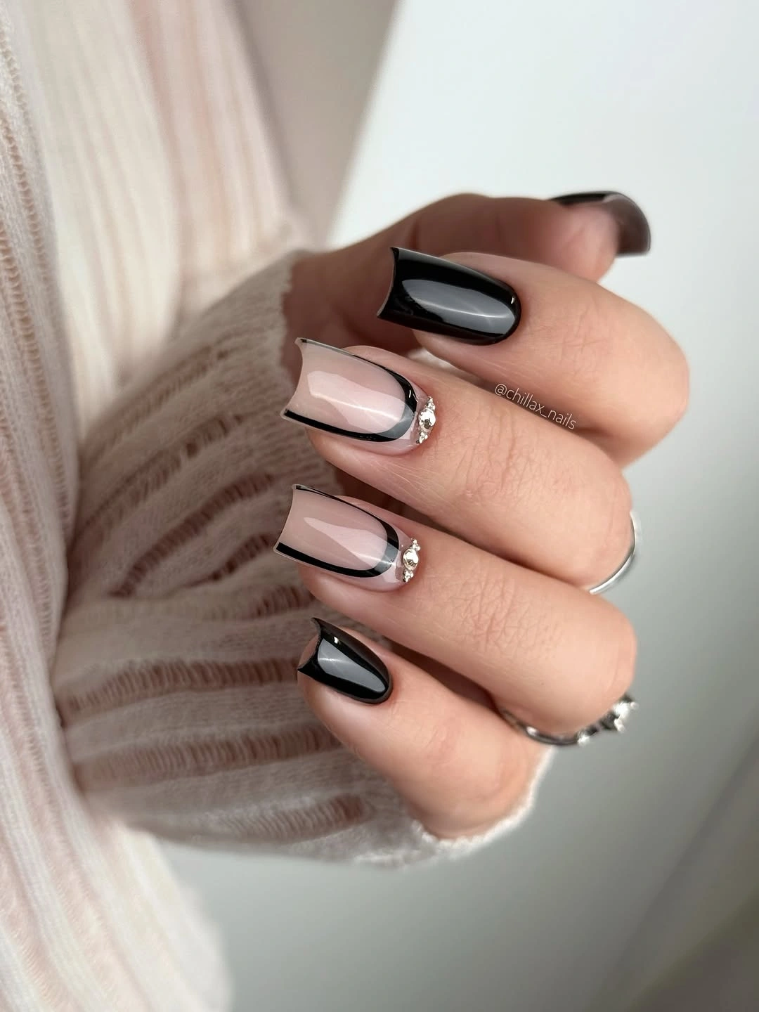 Medium almond nails with black white curved tips and pearls