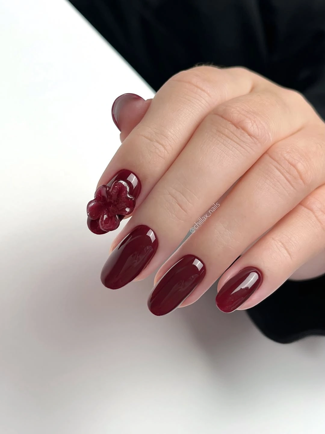 Long deep wine almond nails with one raised floral accent
