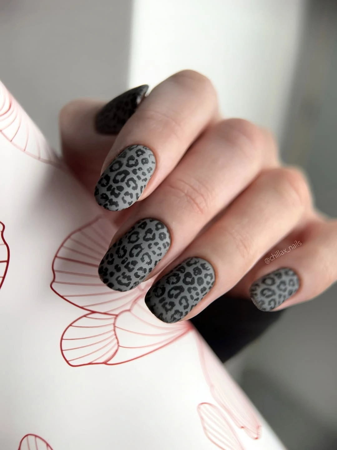 Short gray nails with a black leopard pattern