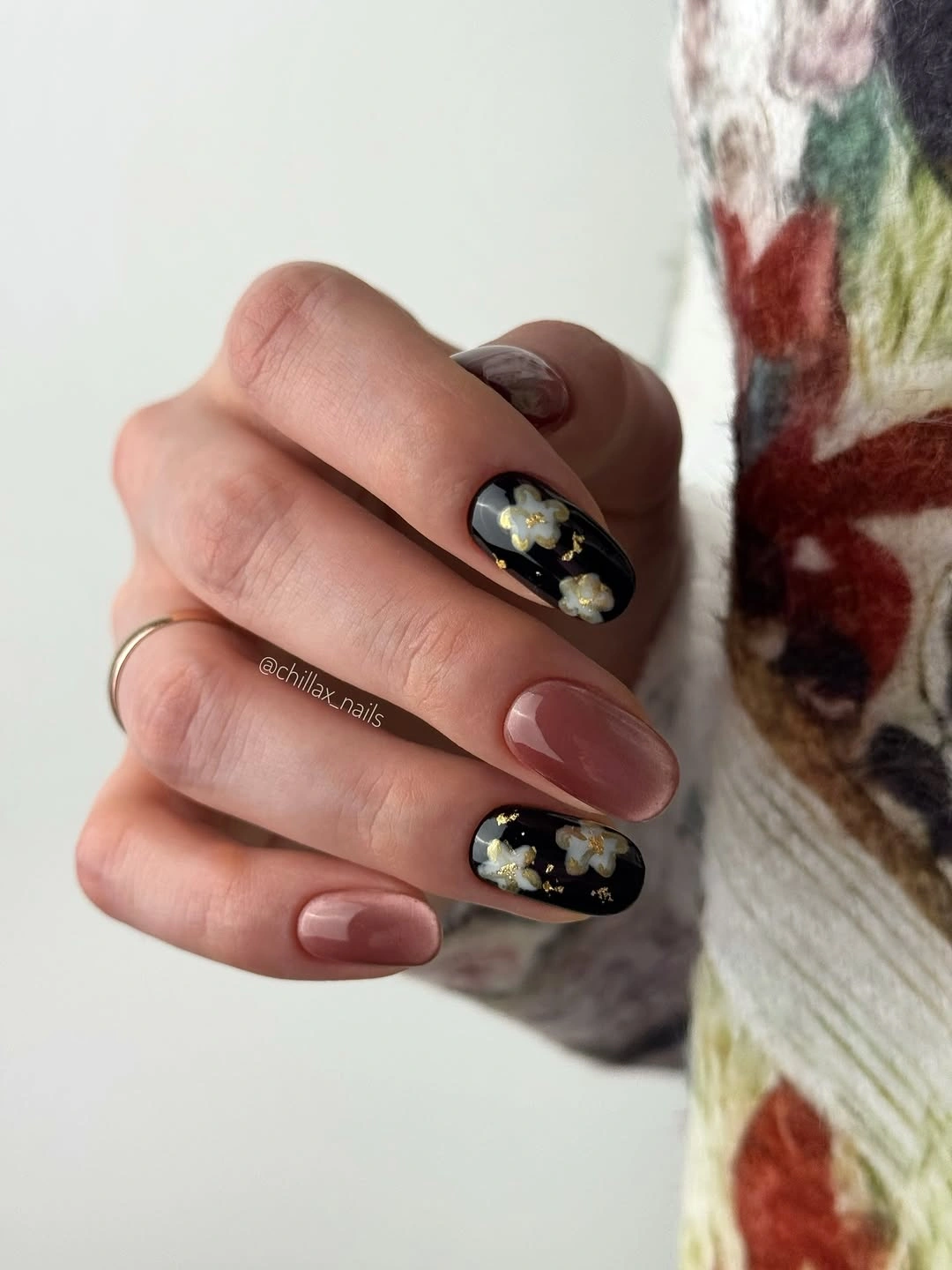 Short nude almond nails with black floral silhouettes