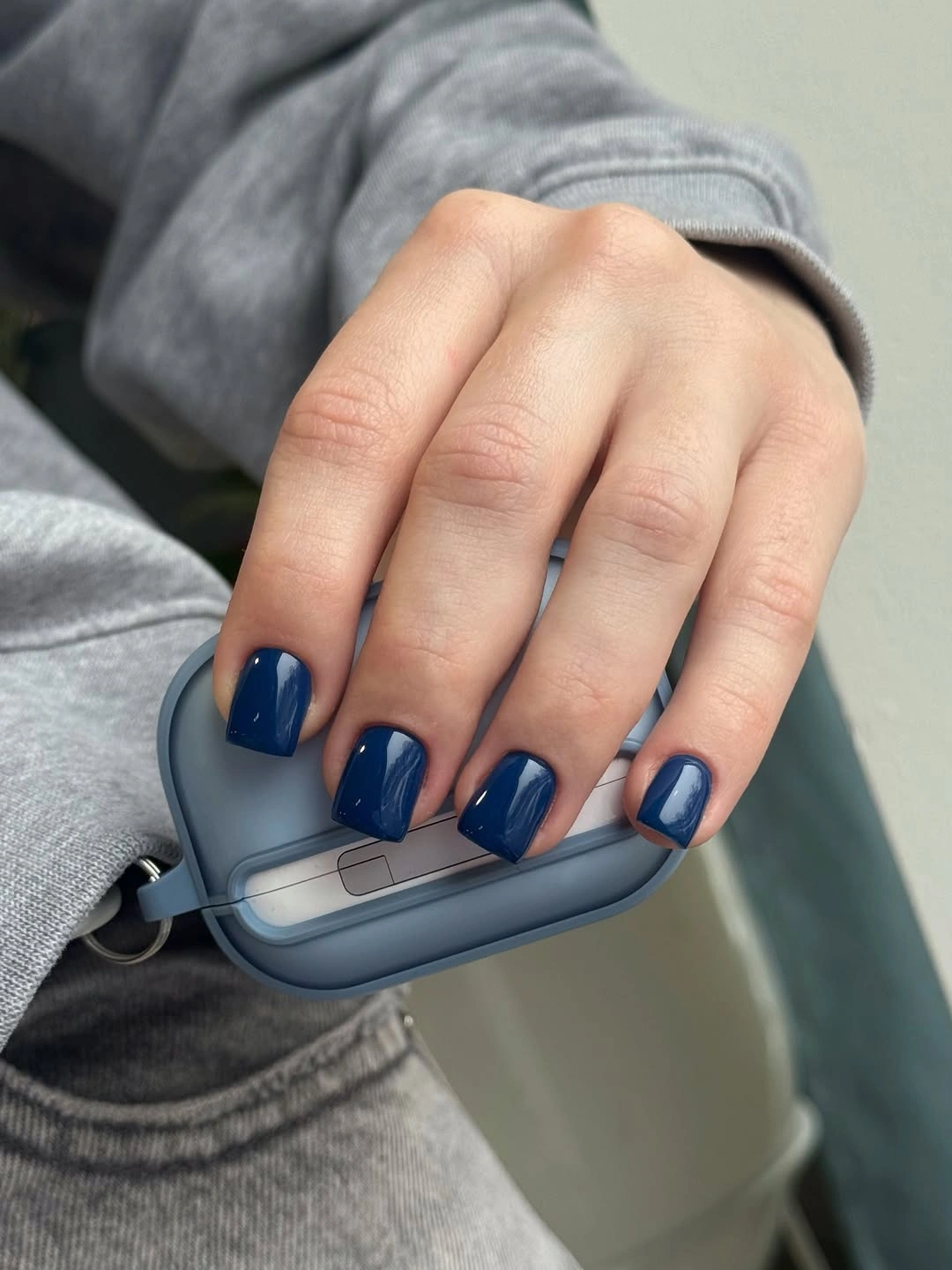 Short square nails coated in saturated glossy cobalt blue